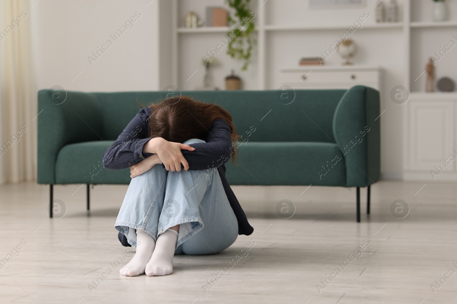 Sad young woman crying on floor at home, space for text Photo of Sad young woman crying on floor at home, space for text