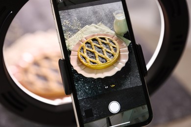 Photo of Shooting tasty pie and milk with smartphone in studio, selective focus. Professional food photography