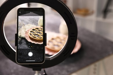 Photo of Shooting tasty pie and milk with smartphone in studio, selective focus. Professional food photography