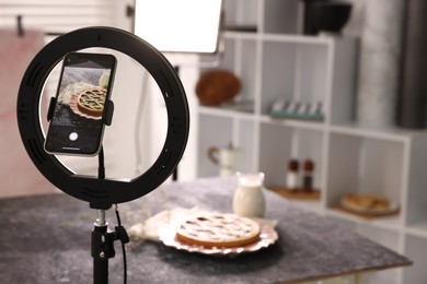 Photo of Shooting tasty pie and milk with smartphone in studio, selective focus. Professional food photography