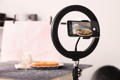 Photo of Shooting tasty pie and milk with smartphone in studio, selective focus. Professional food photography