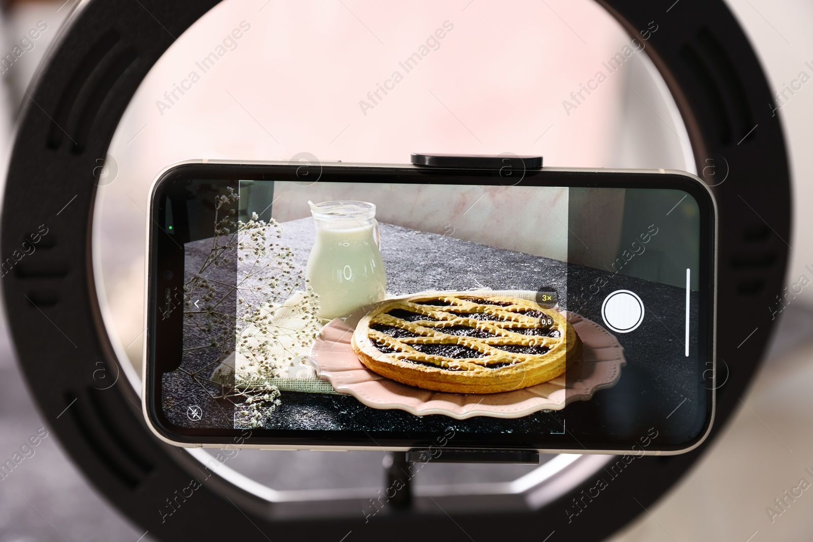 Photo of Shooting tasty pie and milk with smartphone in studio, selective focus. Professional food photography