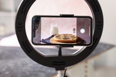 Photo of Shooting tasty pie and milk with smartphone in studio, selective focus. Professional food photography
