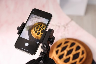Photo of Shooting tasty pie and milk with smartphone in studio, above view. Professional food photography