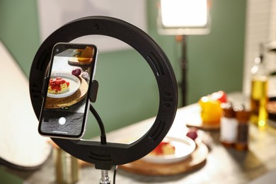 Photo of Shooting tasty pasta and ingredients with smartphone in studio, selective focus. Professional food photography