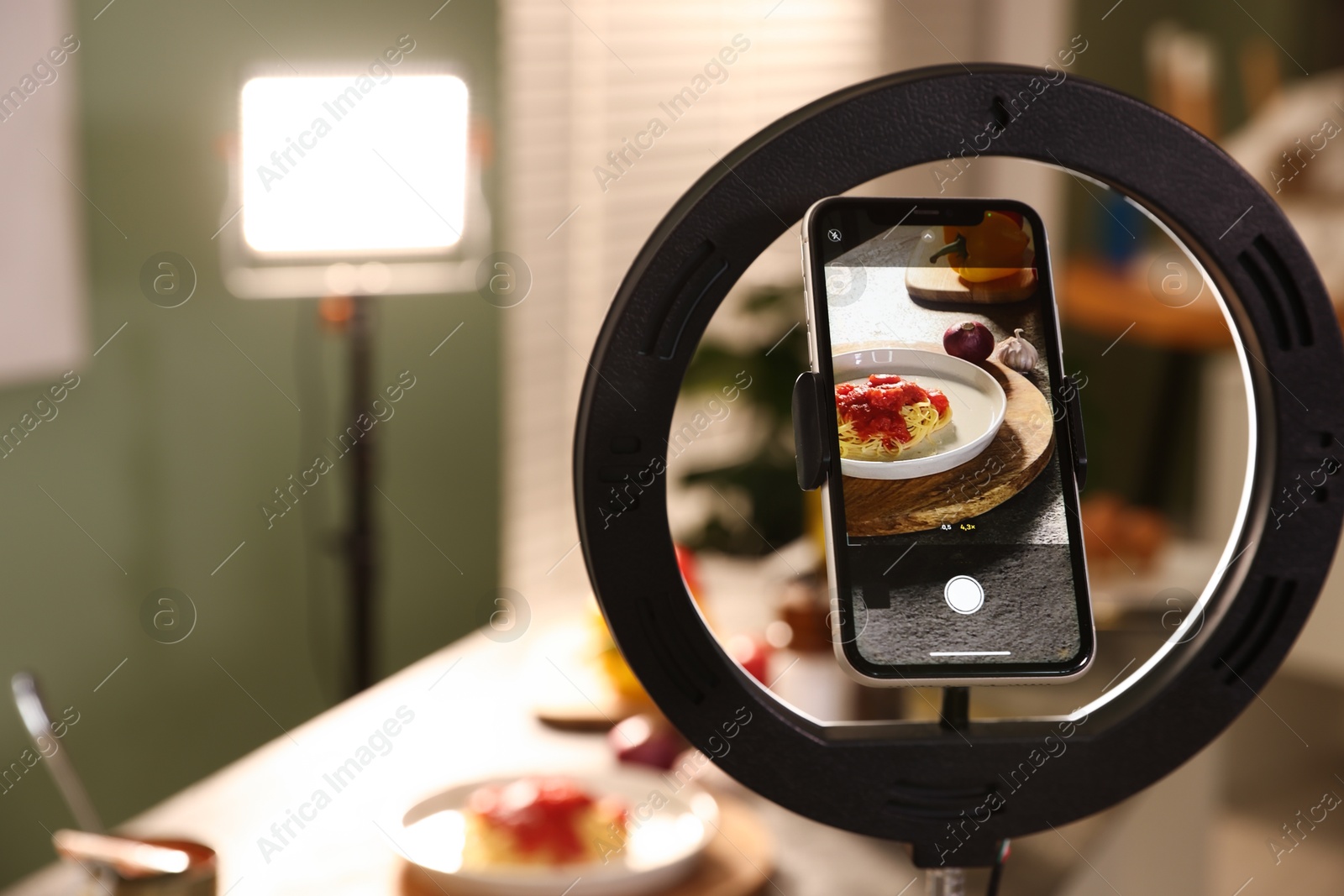 Photo of Shooting tasty pasta and ingredients with smartphone in studio, selective focus. Professional food photography