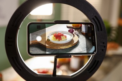 Photo of Shooting tasty pasta and ingredients with smartphone in studio, selective focus. Professional food photography