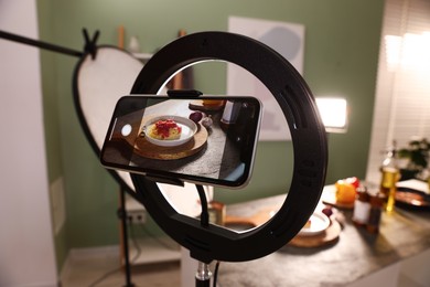 Photo of Shooting tasty pasta and ingredients with smartphone in studio, selective focus. Professional food photography