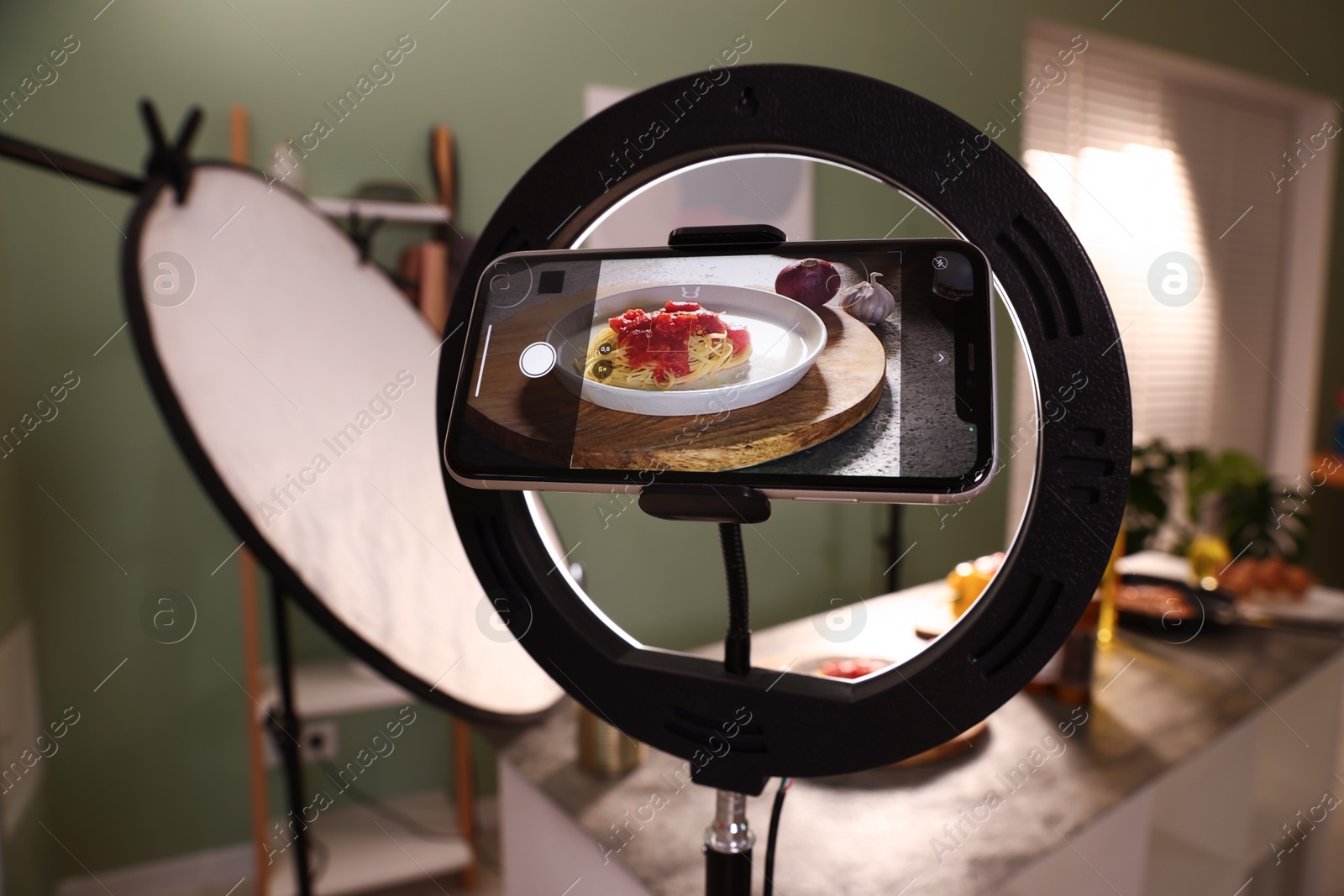 Photo of Shooting tasty pasta and ingredients with smartphone in studio, selective focus. Professional food photography