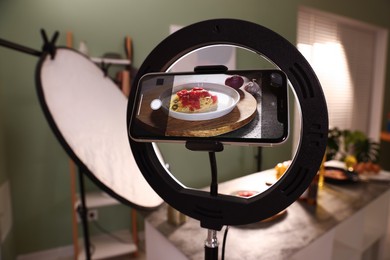 Photo of Shooting tasty pasta and ingredients with smartphone in studio, selective focus. Professional food photography