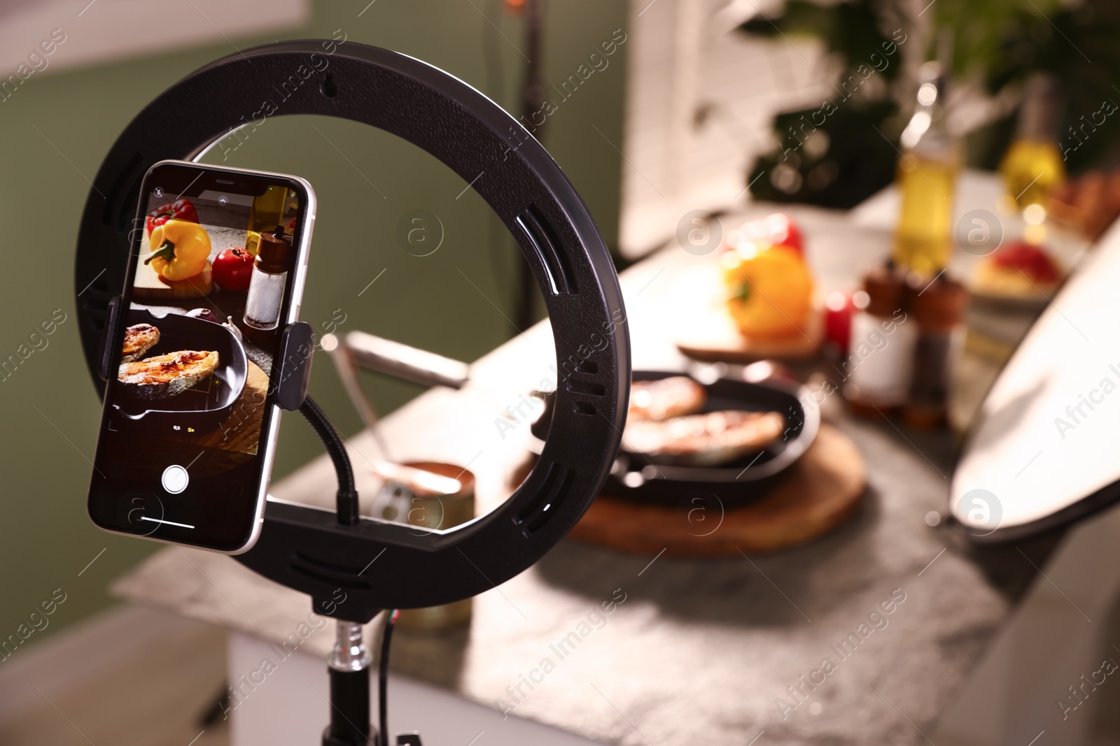 Photo of Shooting tasty roasted fish and ingredients with smartphone in studio, selective focus. Professional food photography