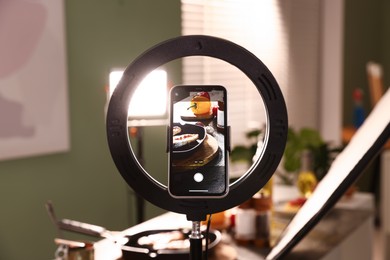 Photo of Shooting tasty roasted fish with smartphone in studio, selective focus. Professional food photography