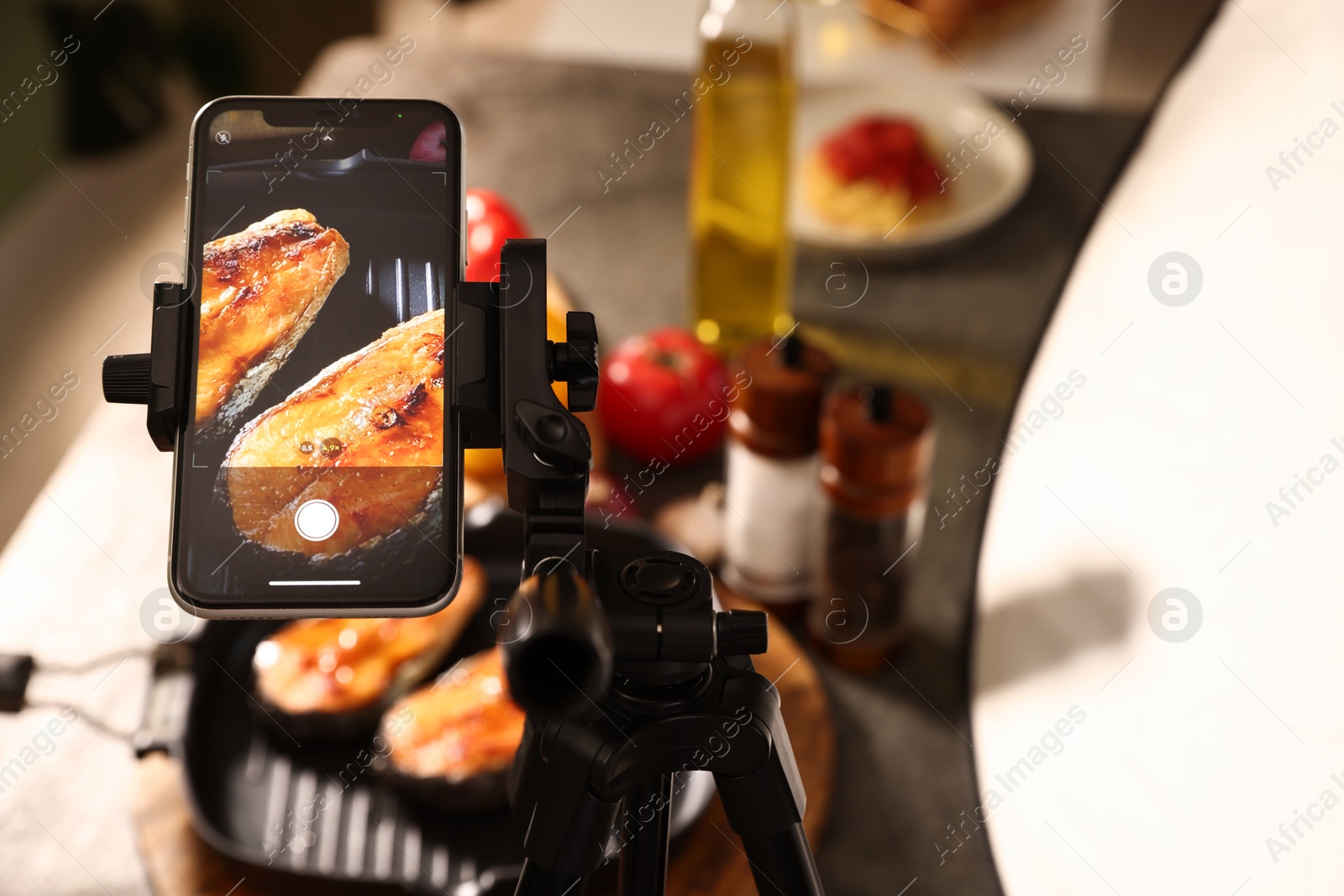 Photo of Shooting tasty roasted fish with smartphone in studio, above view. Professional food photography