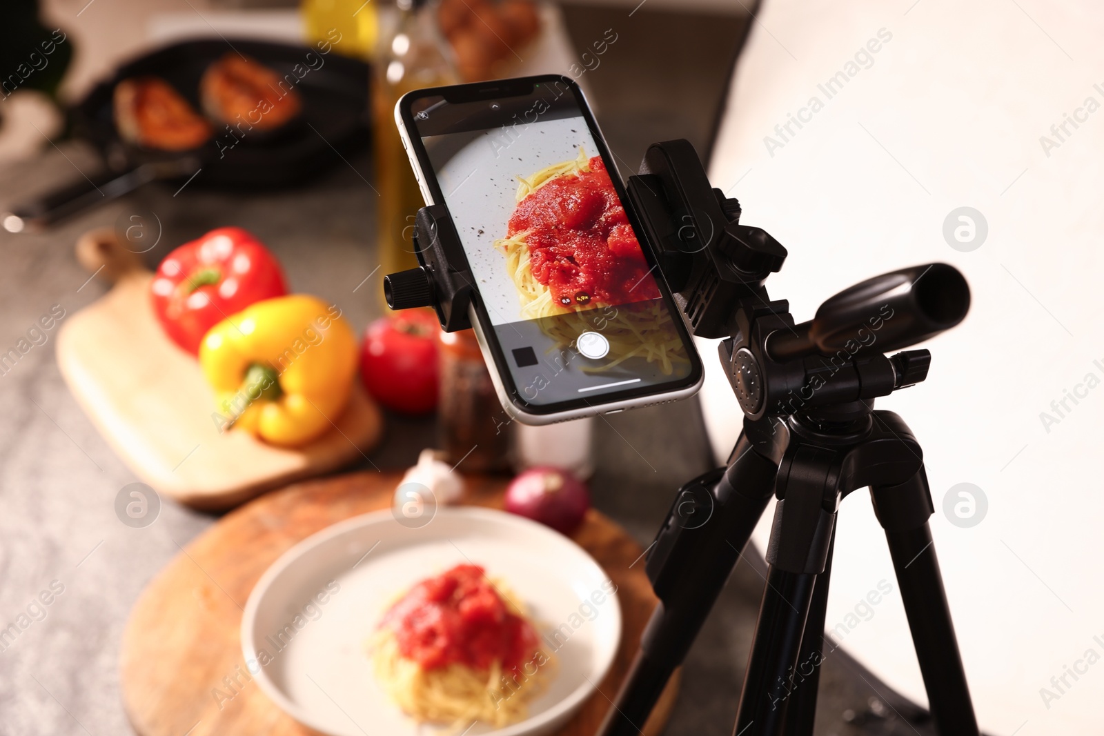 Photo of Shooting tasty pasta with smartphone in studio, selective focus. Professional food photography