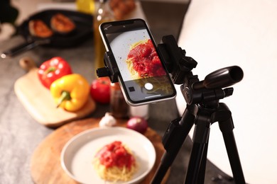 Photo of Shooting tasty pasta with smartphone in studio, selective focus. Professional food photography