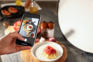 Photo of Woman taking picture of tasty pasta and ingredients in studio, selective focus. Professional food photography