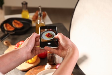 Photo of Woman taking picture of tasty pasta and ingredients in studio, selective focus. Professional food photography