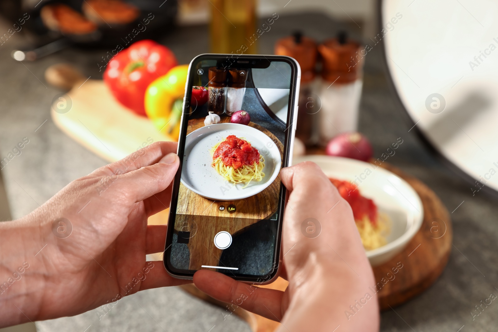 Photo of Woman taking picture of tasty pasta and ingredients in studio, selective focus. Professional food photography
