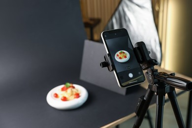 Photo of Shooting tasty pasta with smartphone in studio, focus on screen. Professional food photography