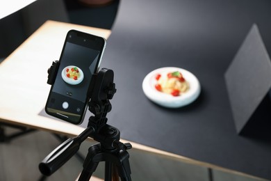 Photo of Shooting tasty pasta with smartphone in studio, focus on screen. Professional food photography