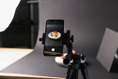 Photo of Shooting tasty pasta with smartphone in studio, focus on screen. Professional food photography