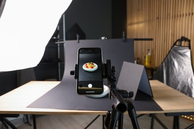 Photo of Shooting tasty pasta with smartphone in studio, focus on screen. Professional food photography