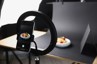 Photo of Shooting tasty pasta with smartphone in studio, focus on screen. Professional food photography