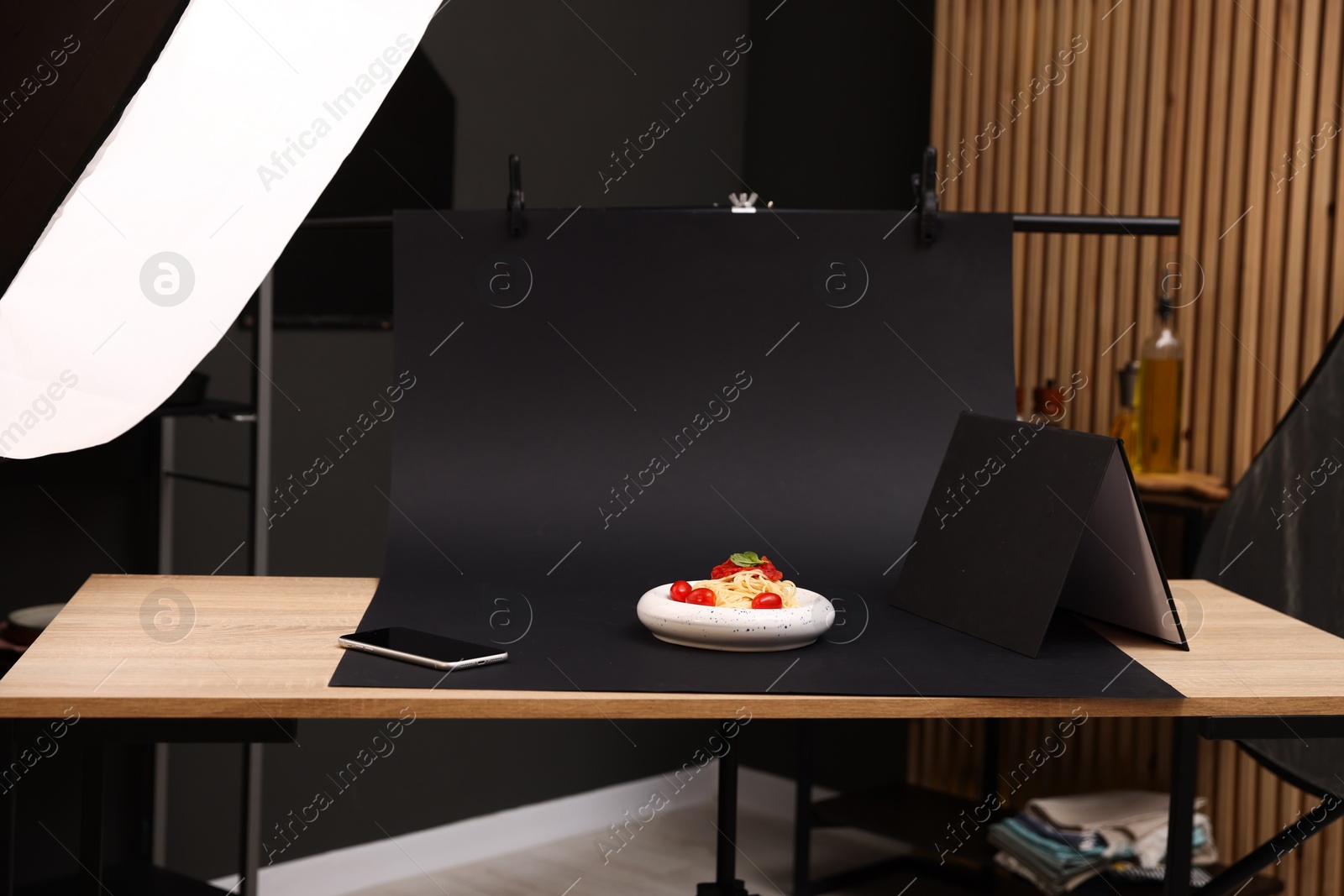 Photo of Shooting tasty pasta with smartphone in studio, focus on screen. Professional food photography