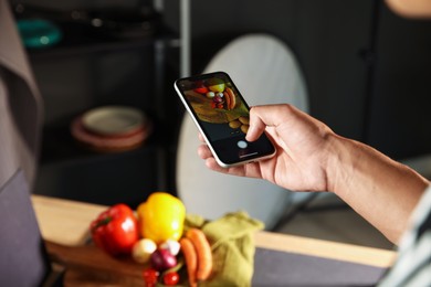 Photo of Woman taking picture of vegetables with smartphone in studio, closeup. Professional food photography