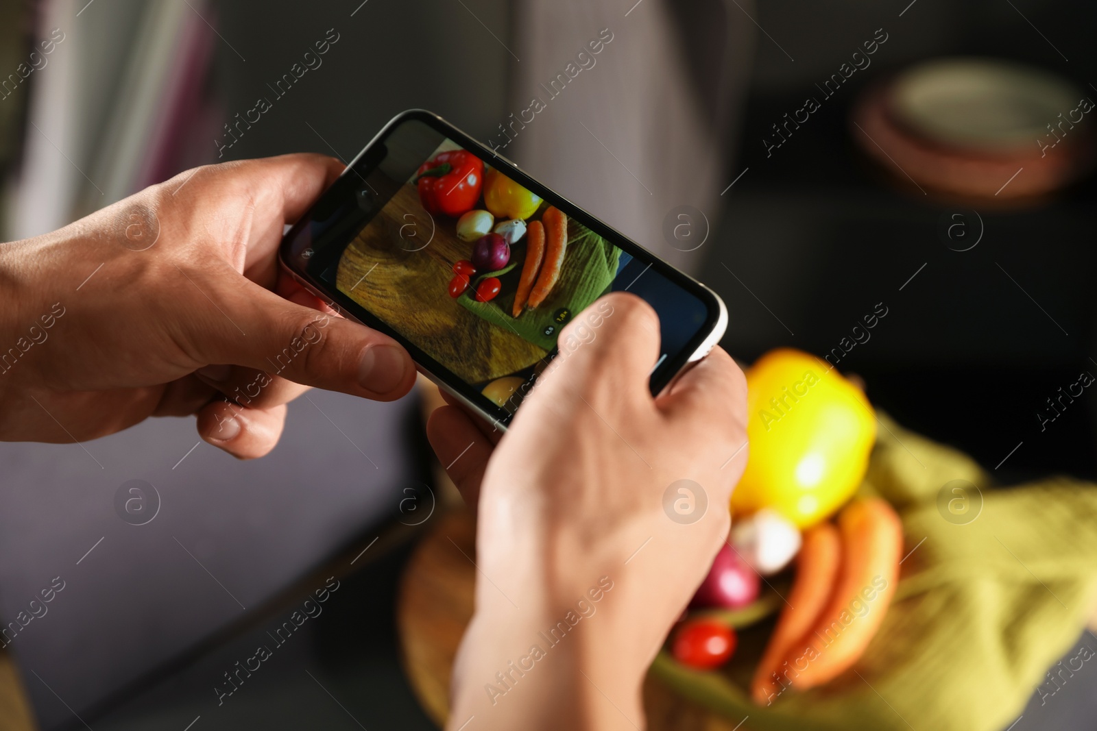 Photo of Woman taking picture of vegetables with smartphone in studio, closeup. Professional food photography