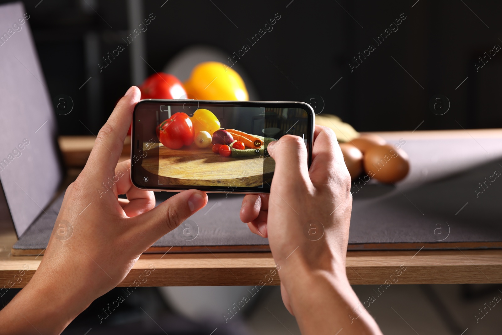 Photo of Woman taking picture of vegetables with smartphone in studio, closeup. Professional food photography
