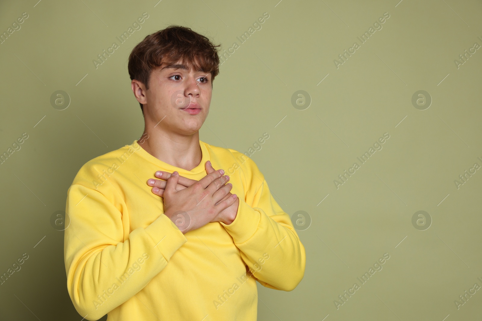 Photo of Teenage boy deep breathing on green background, space for text. Way to stop panic attack