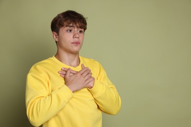 Photo of Teenage boy deep breathing on green background, space for text. Way to stop panic attack