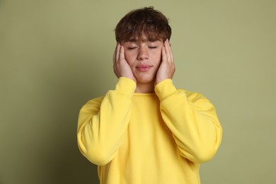 Photo of Teenage boy meditating on green background. Way to stop panic attack