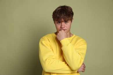Photo of Teenage boy suffering from panic attack on green background