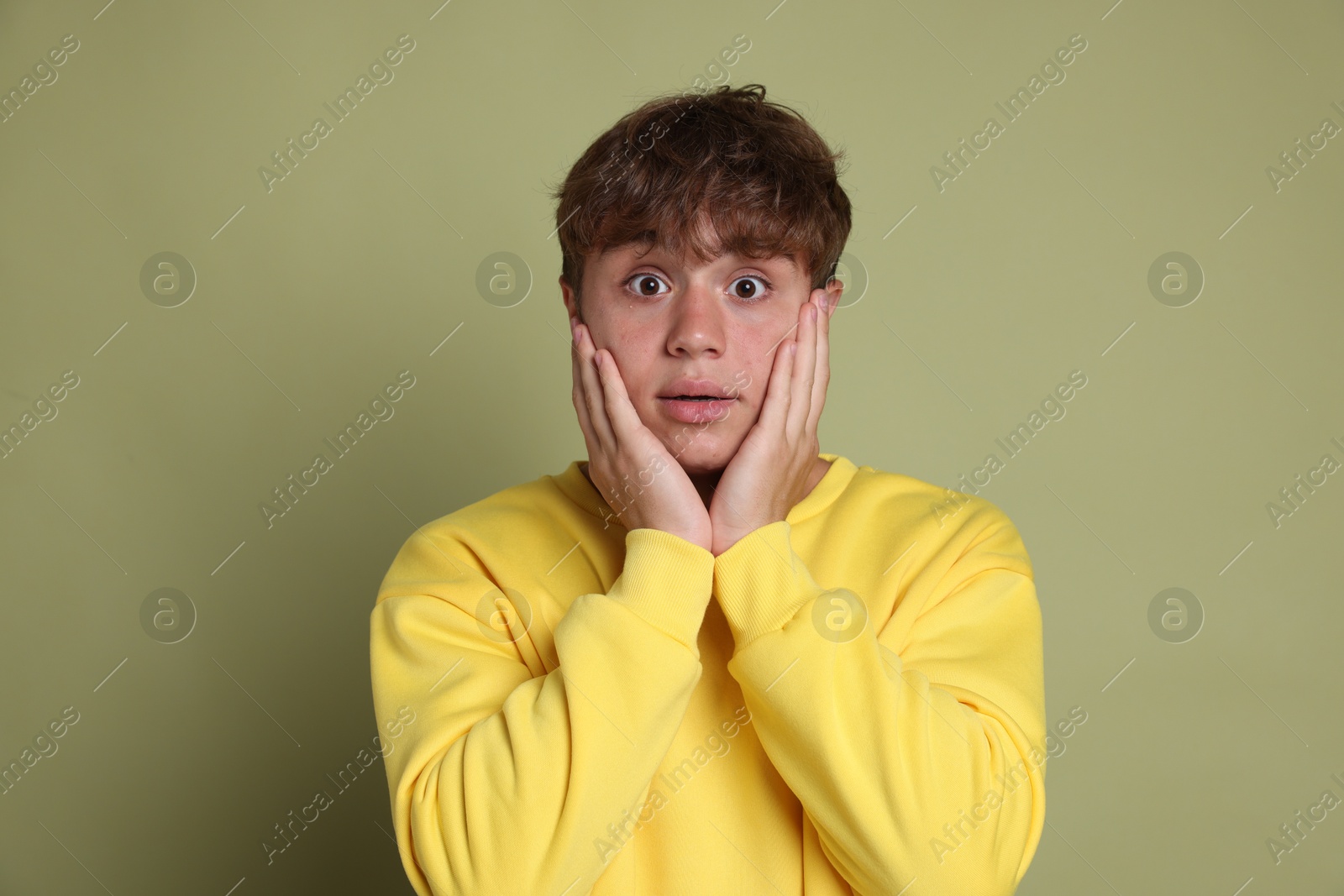 Photo of Teenage boy suffering from panic attack on green background