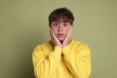 Photo of Teenage boy suffering from panic attack on green background
