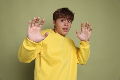 Photo of Teenage boy suffering from panic attack on green background