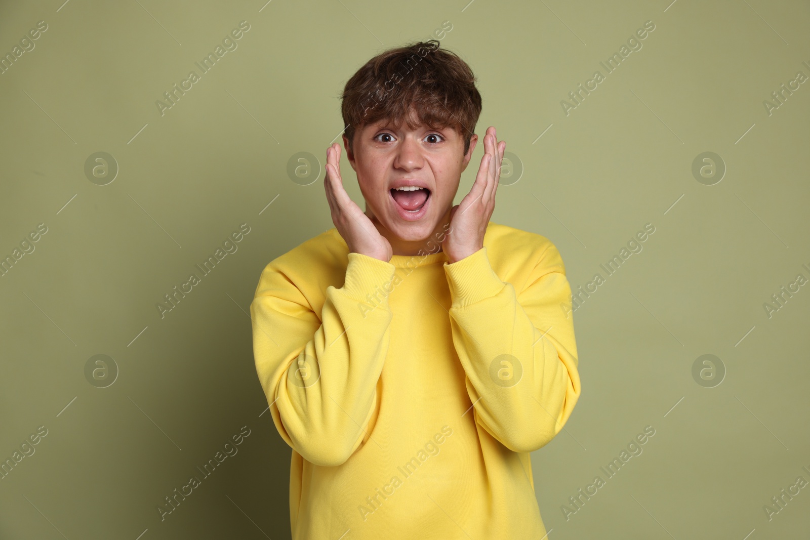 Photo of Teenage boy suffering from panic attack on green background