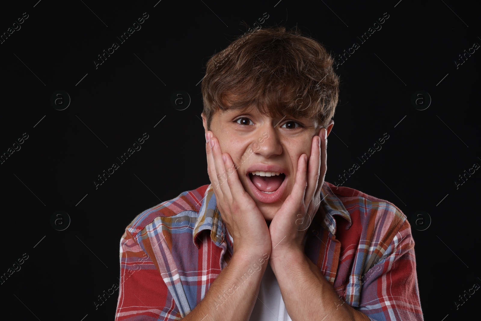 Photo of Teenage boy suffering from panic attack on black background