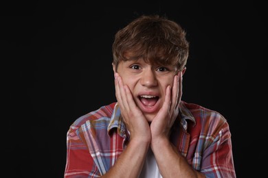 Photo of Teenage boy suffering from panic attack on black background