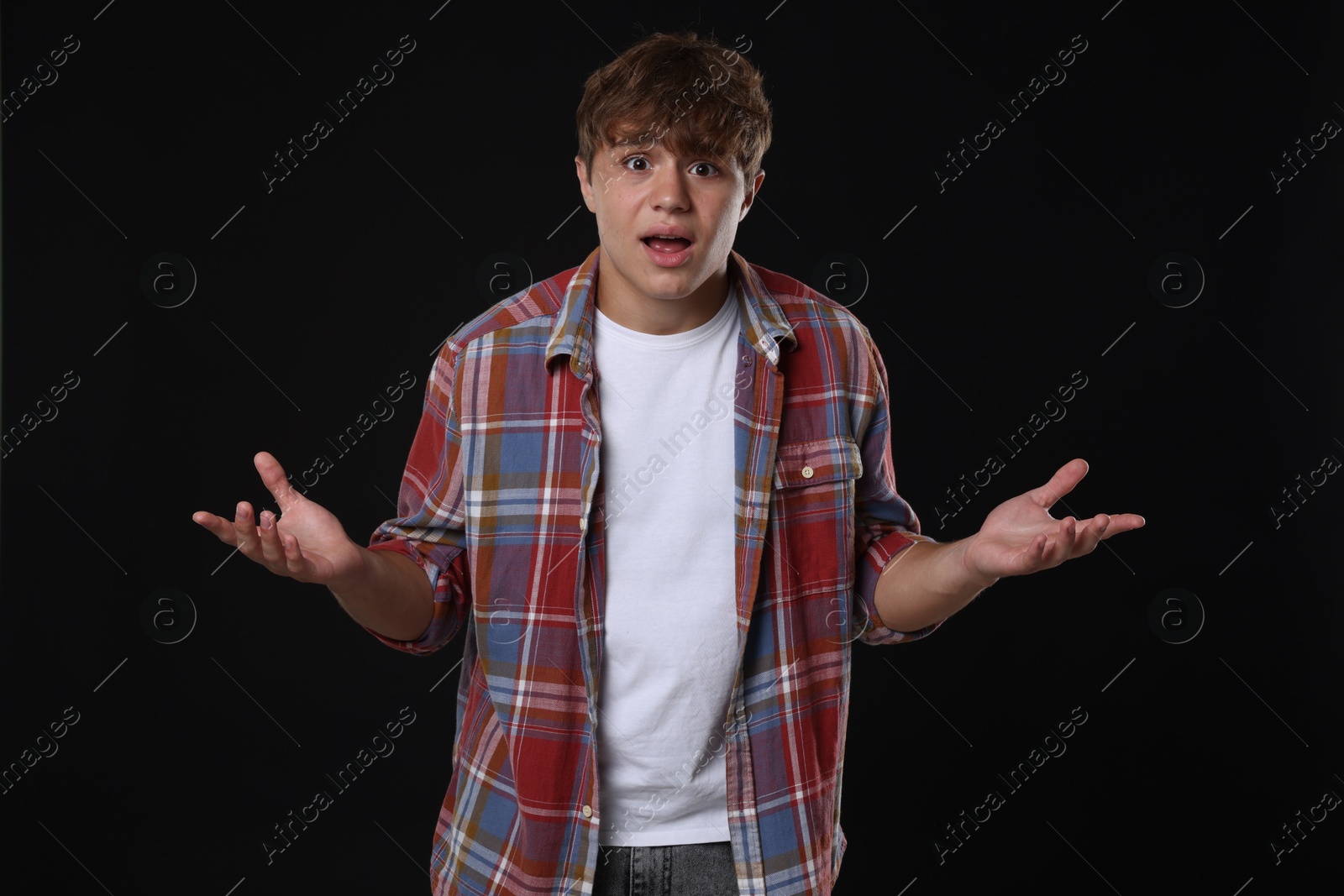 Photo of Teenage boy suffering from panic attack on black background