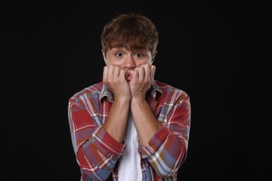 Photo of Teenage boy suffering from panic attack on black background