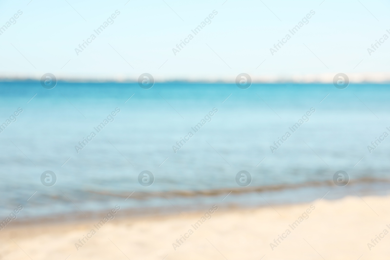 Photo of Beautiful sea and shore under light blue sky, blurred view