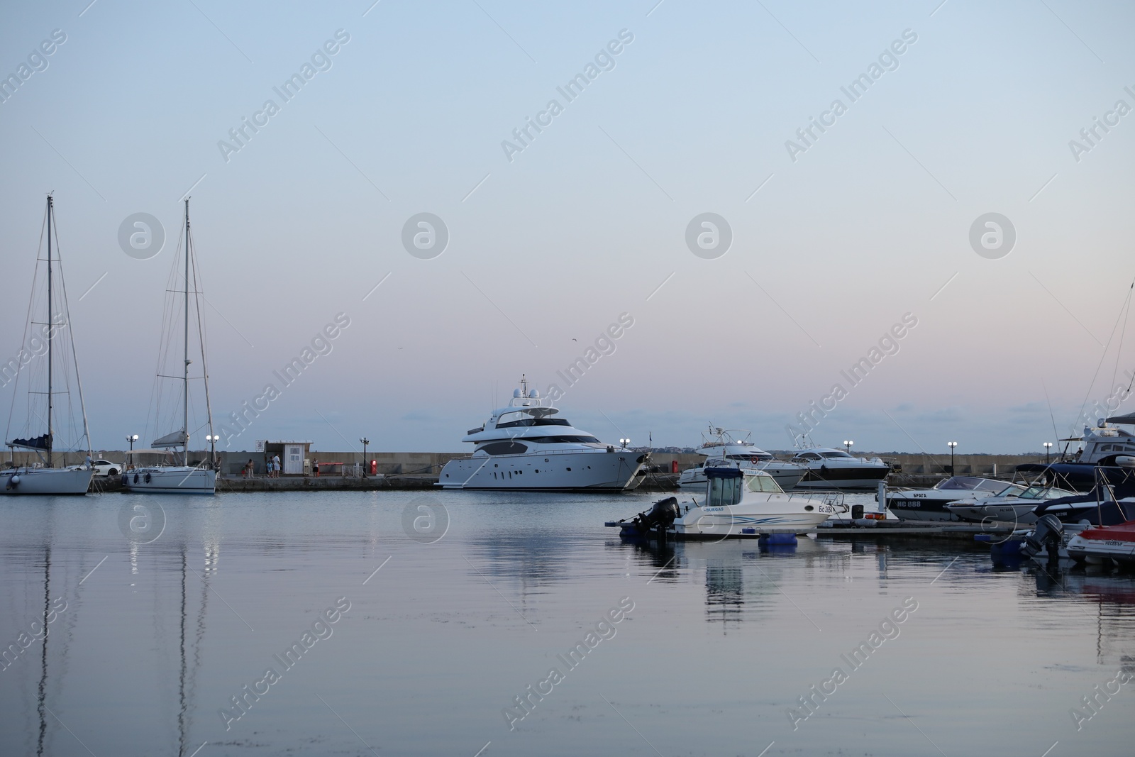 Photo of Sveti Vlas, Bulgaria - July 11, 2025: Moored ferries and boats in sea port at sunset