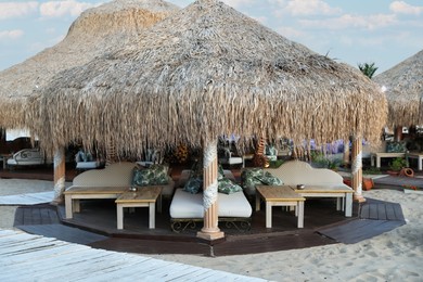 Photo of Beautiful gazebo with comfortable furniture at luxury resort outdoors