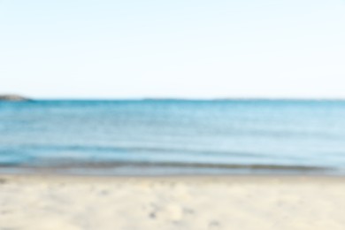 Photo of Beautiful sea and shore under light blue sky, blurred view
