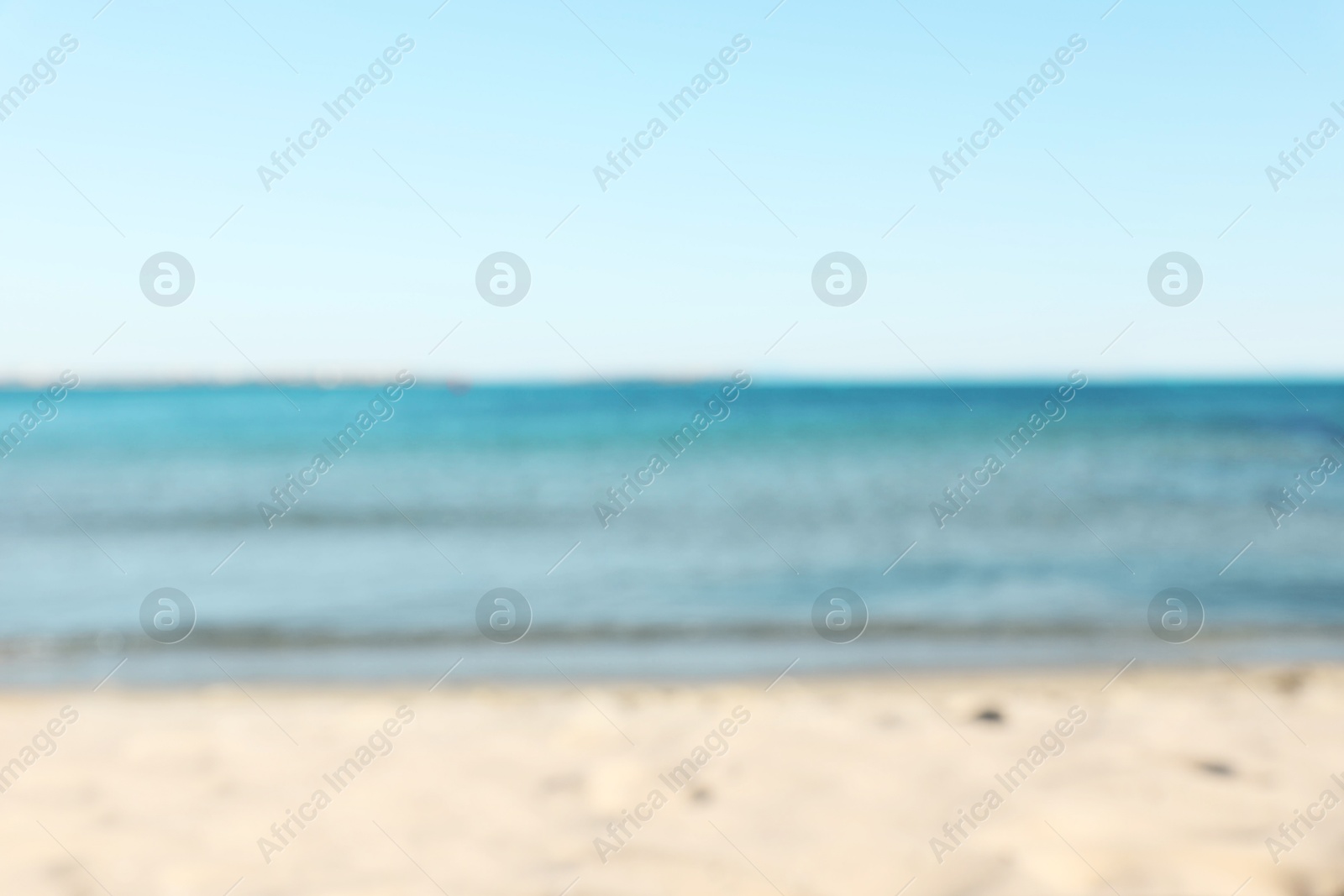 Photo of Beautiful sea and shore under light blue sky, blurred view