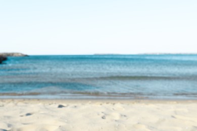 Photo of Beautiful sea and shore under light blue sky, blurred view