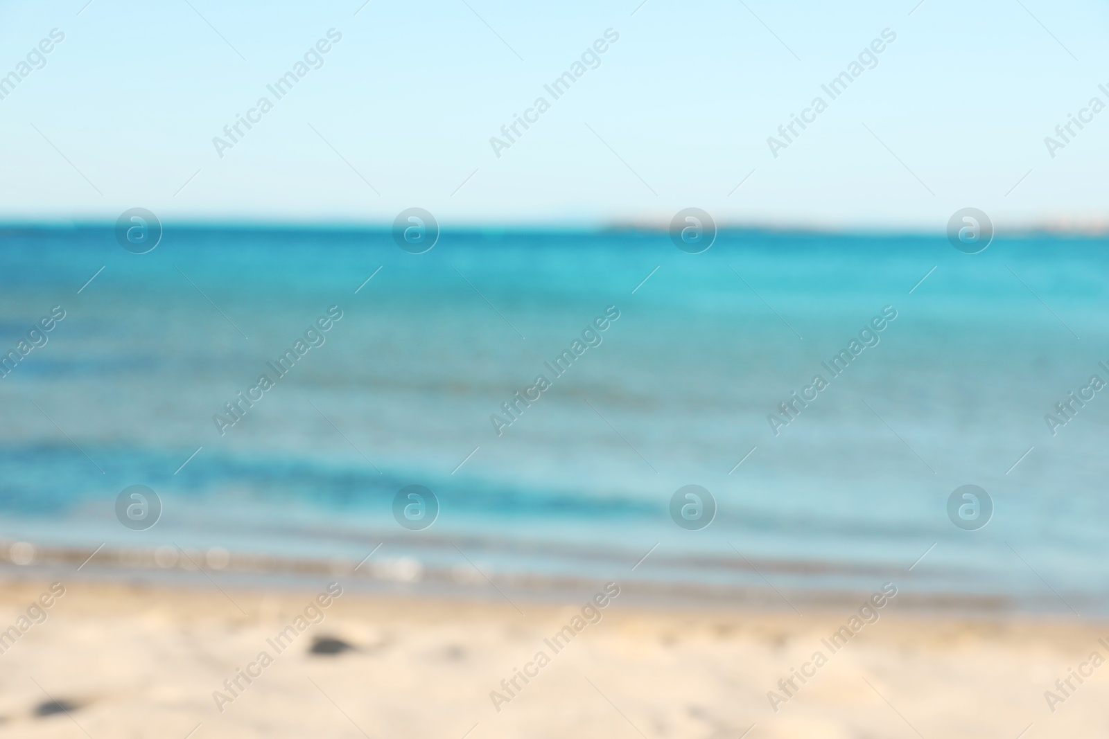 Photo of Beautiful sea and shore under light blue sky, blurred view